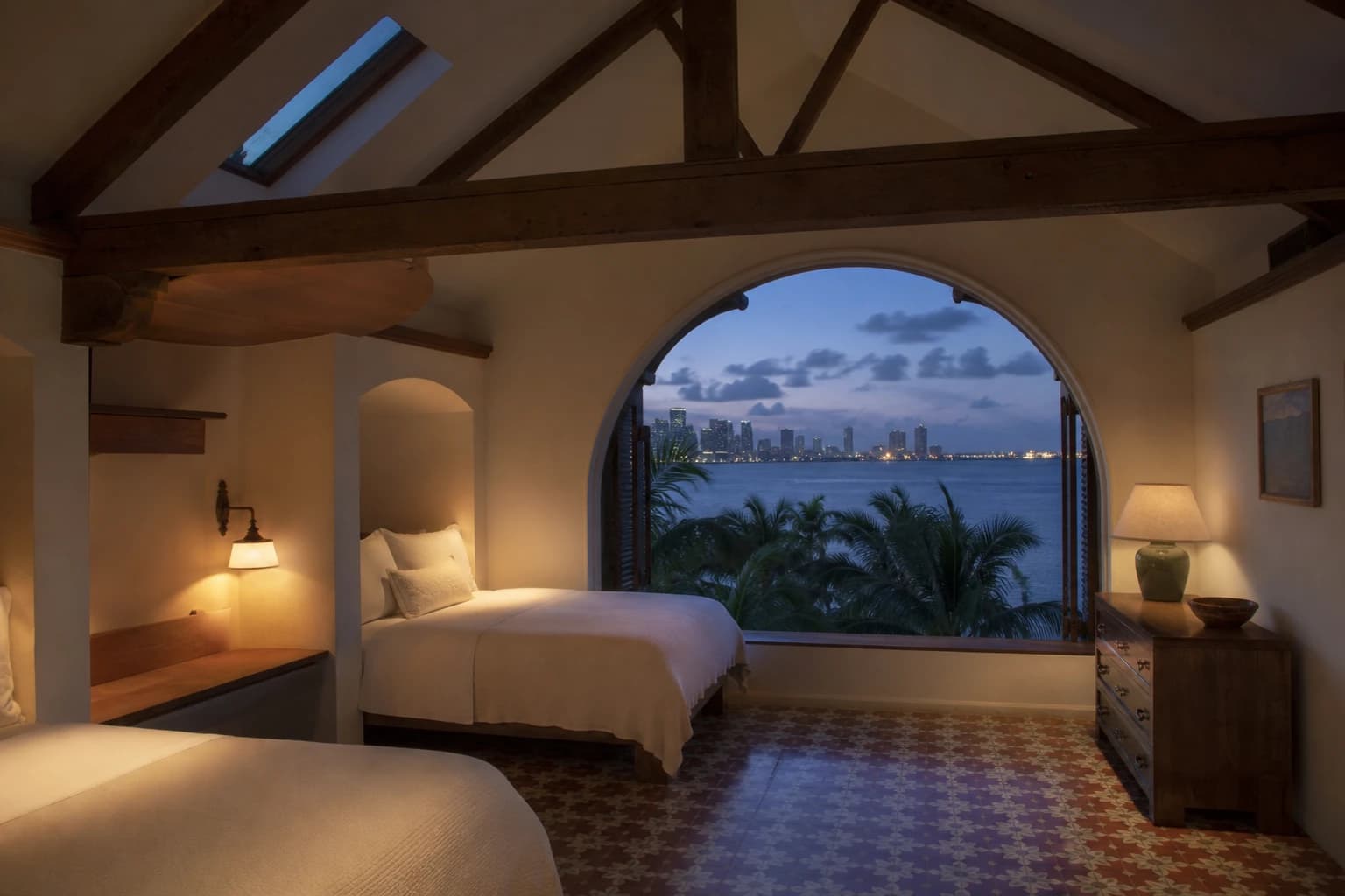 Loft suite — view through east dormer toward bay, palm tops in foreground, blue hour